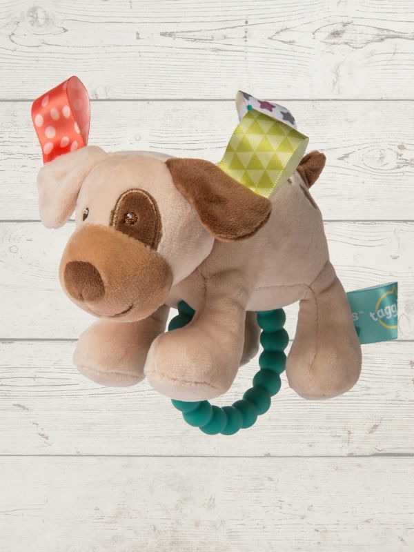 Plush dog toy with a teething ring on a wooden surface