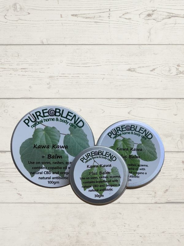 Three containers of Pure Blend Kawa Kawa Plus Balm on a light wooden surface