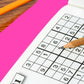 A puzzle book with a pen on top, featuring a grid of numbers and a pink eraser behind it.
