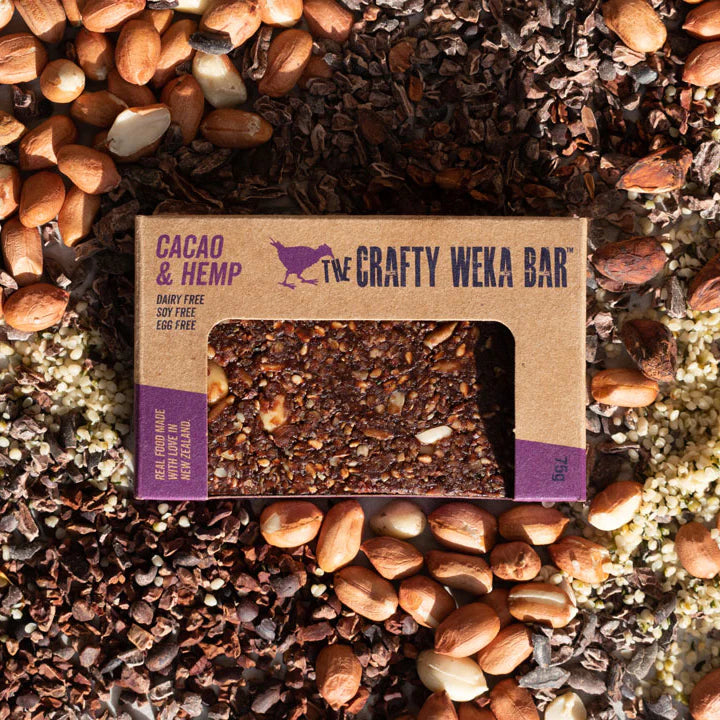 The Crafty Weka Bar packaging on a bed of cacao nibs and nuts