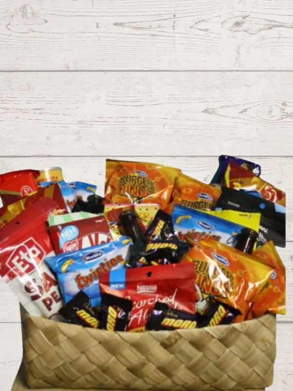 A wicker basket filled with a variety of snack items, such as chips and candy, packaged in individual bags.