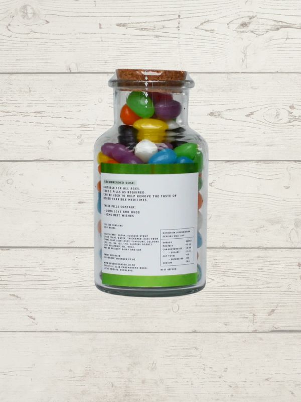 Bottle of colorful jelly beans on a light wooden surface
