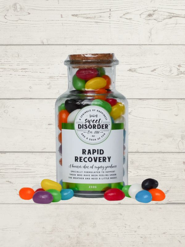 Jar of jelly beans with a label reading 'Sweet Disorder' on a wooden surface.