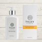 A collection of Tilley branded room spray bottles displayed against a wooden background. The bottles are varied in size and design, with a consistent white and silver label design featuring the Tilley logo.