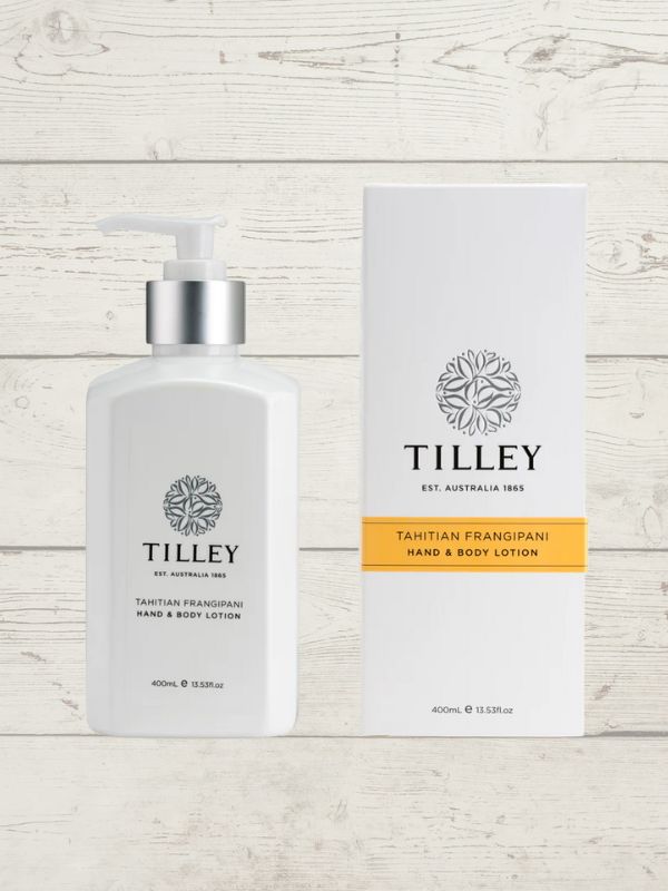A collection of Tilley branded room spray bottles displayed against a wooden background. The bottles are varied in size and design, with a consistent white and silver label design featuring the Tilley logo.