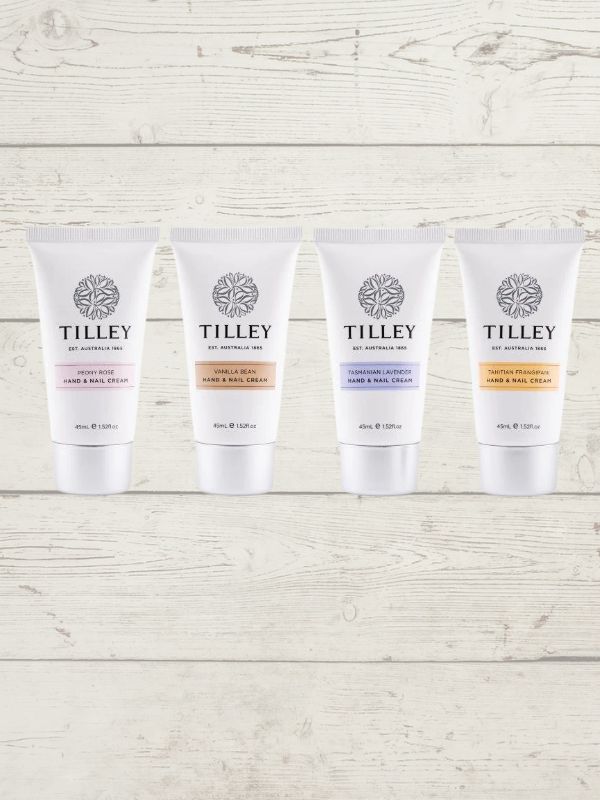 Four tubes of Tilley Hand Cream in different shades, displayed upright on a wooden surface.