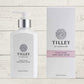 A collection of Tilley branded room spray bottles displayed against a wooden background. The bottles are varied in size and design, with a consistent white and silver label design featuring the Tilley logo.