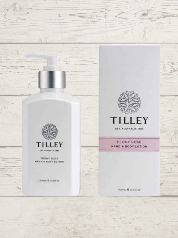 A collection of Tilley branded room spray bottles displayed against a wooden background. The bottles are varied in size and design, with a consistent white and silver label design featuring the Tilley logo.