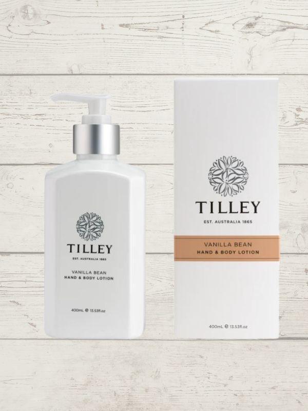 A collection of Tilley branded room spray bottles displayed against a wooden background. The bottles are varied in size and design, with a consistent white and silver label design featuring the Tilley logo.