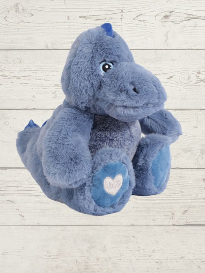 Blue plush dinosaur toy with a heart on a light wooden background