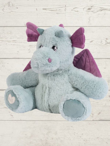 Plush dragon toy with purple wings on a light wooden floor