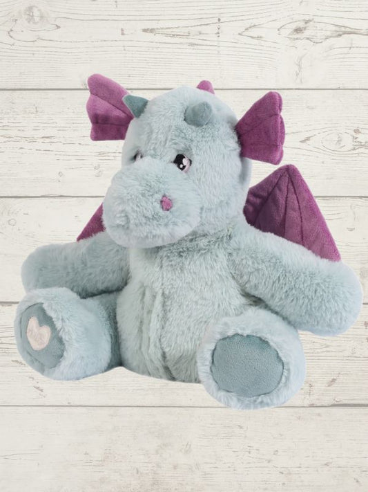 Plush dragon toy with purple wings on a light wooden floor