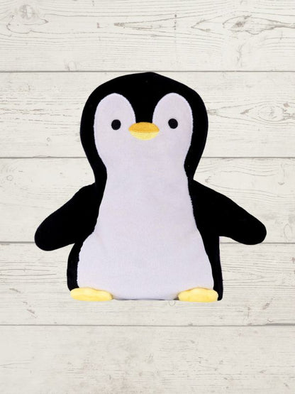 Plush penguin toy on a light wooden surface