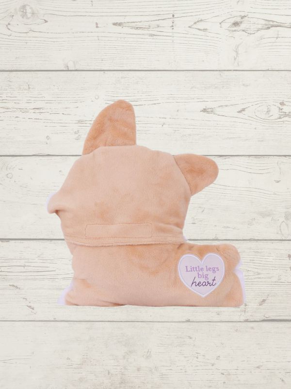 Pink plush toy shaped like a dog on a wooden surface with a heart-shaped tag.