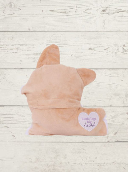 Pink plush toy shaped like a dog on a wooden surface with a heart-shaped tag.