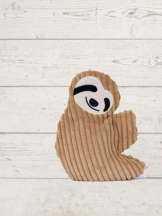 Brown knitted sloth toy on a light wooden surface