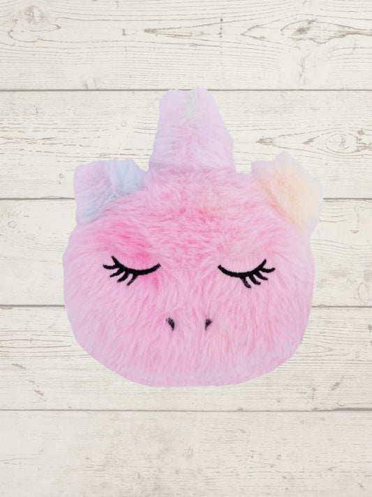 Pink plush toy with unicorn design on a wooden surface