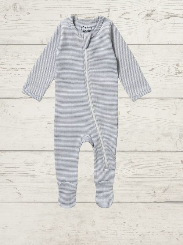A long sleeve rib zipsuit for babies, with feet and fold-over mittens, in a blue color, displayed on a wooden background.